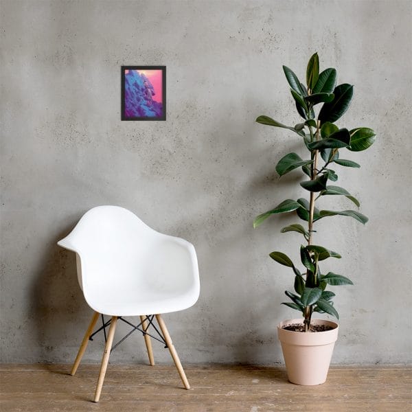 A Framed poster sits in front of a wall with a colorful painting.